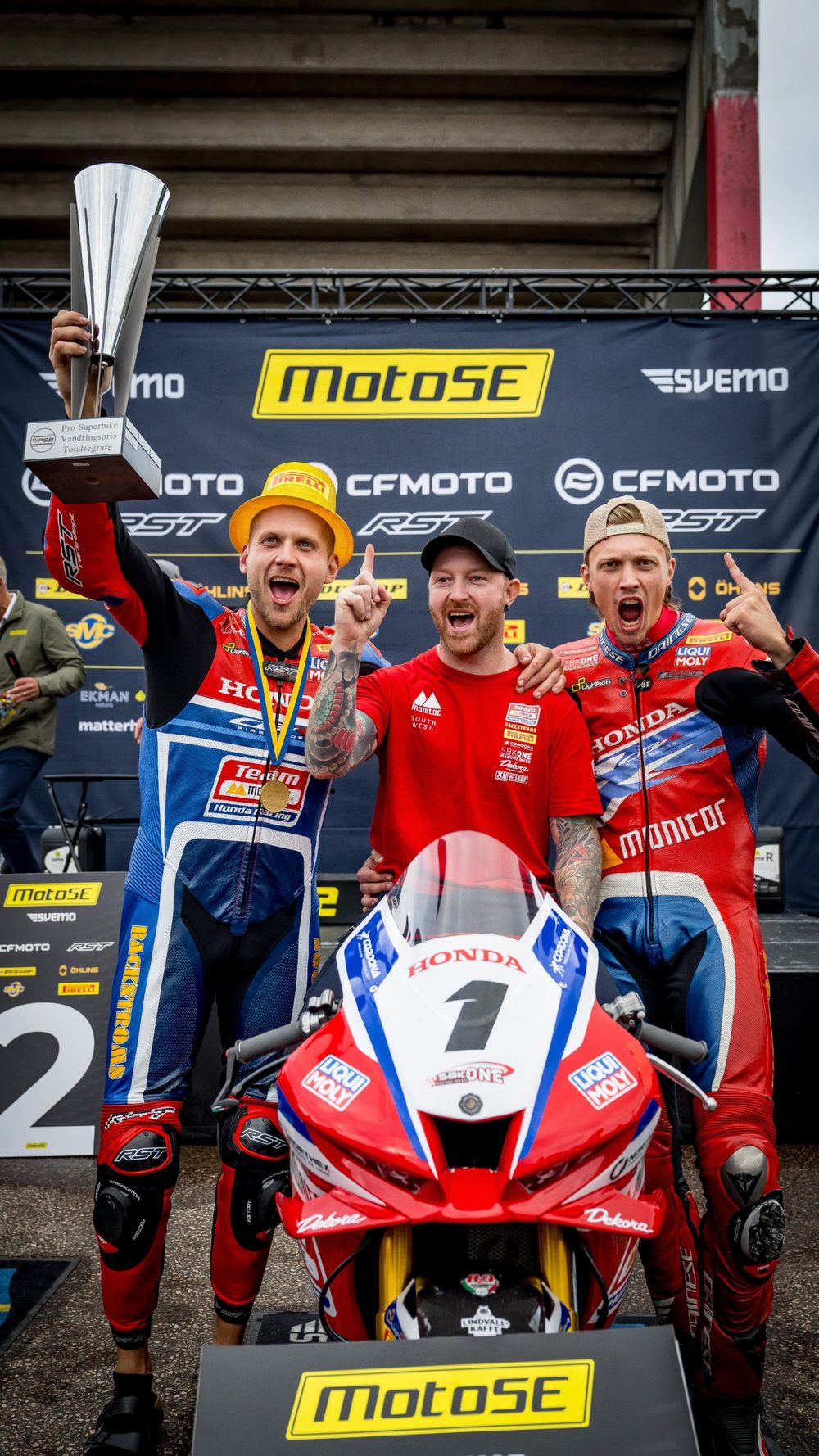 Teamet firar vid MotoSE-podiet med pokalen och motorcykel nummer 1